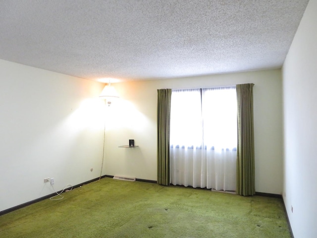 unfurnished room featuring visible vents, light colored carpet, a textured ceiling, and baseboards