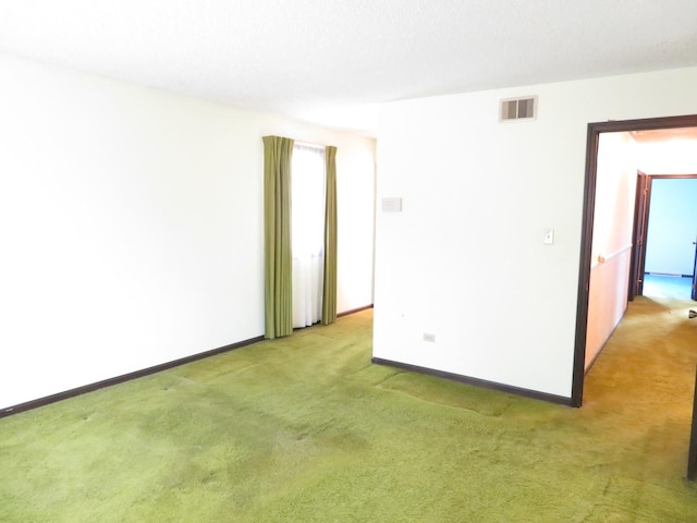 empty room featuring carpet, visible vents, and baseboards