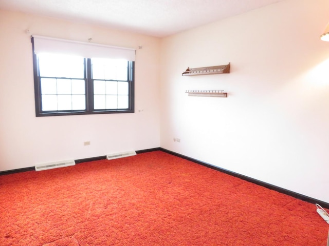 carpeted empty room featuring visible vents and baseboards