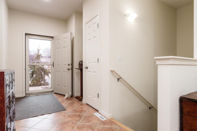 foyer entrance featuring baseboards, visible vents, and light tile patterned flooring