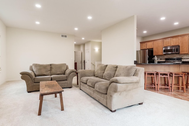 living room with recessed lighting, visible vents, and light carpet