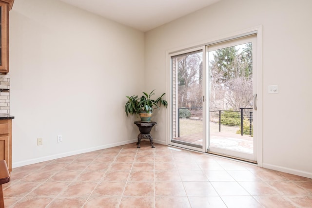 unfurnished room featuring light tile patterned flooring and baseboards