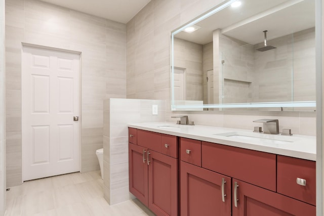 full bath with double vanity, tile walls, a tile shower, and a sink