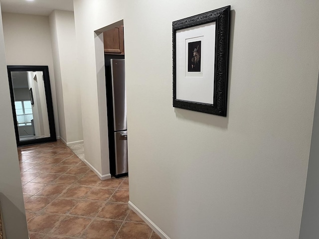 hall with tile patterned flooring and baseboards