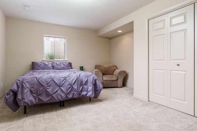 carpeted bedroom with a closet, visible vents, and baseboards