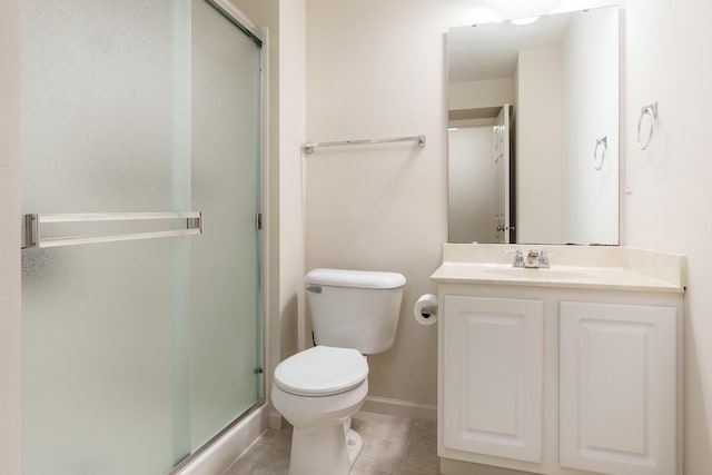 bathroom featuring toilet, a stall shower, vanity, and tile patterned floors