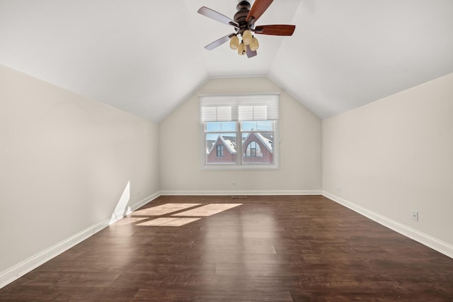 additional living space featuring vaulted ceiling, ceiling fan, dark wood-type flooring, and baseboards