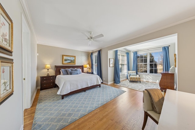 bedroom featuring a ceiling fan, light wood-style floors, baseboards, and ornamental molding