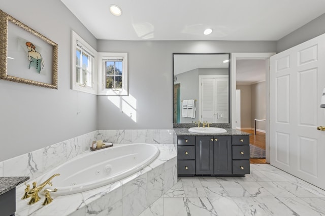 full bath with recessed lighting, marble finish floor, a tub with jets, and vanity