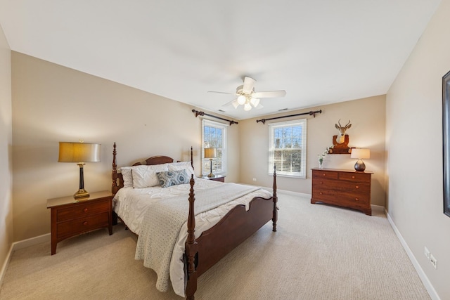 bedroom featuring light carpet, a ceiling fan, and baseboards