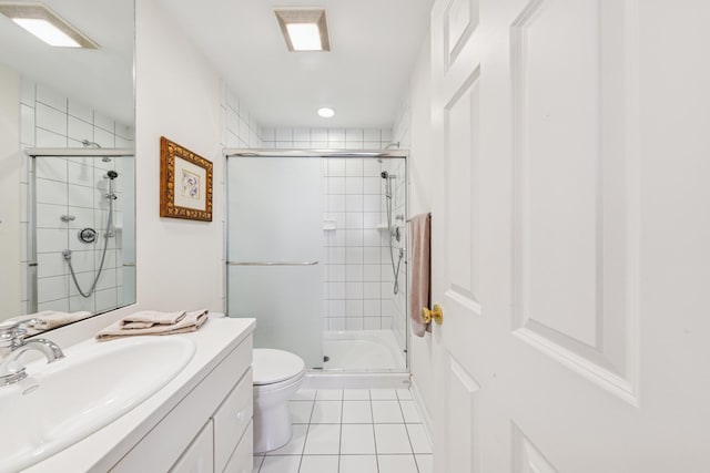 bathroom featuring vanity, toilet, a stall shower, and tile patterned flooring