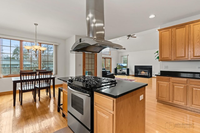 kitchen featuring dark countertops, light wood finished floors, island range hood, and gas stove