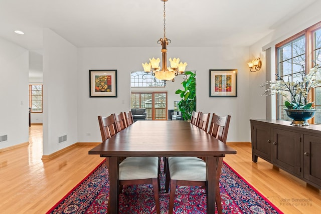 dining space with a healthy amount of sunlight, light wood-style floors, and visible vents