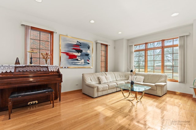 living area with baseboards, wood finished floors, and recessed lighting