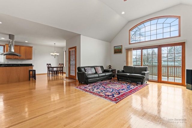 living area with a chandelier, recessed lighting, baseboards, and light wood finished floors