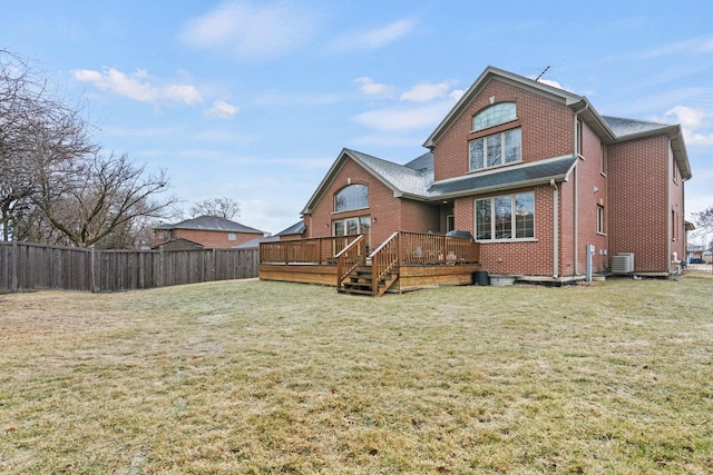 rear view of house with central AC unit, brick siding, fence, a yard, and a wooden deck