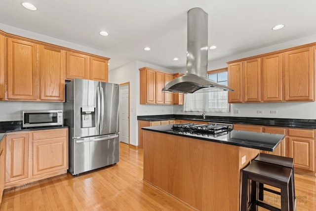 kitchen with a center island, recessed lighting, appliances with stainless steel finishes, light wood-style floors, and island range hood