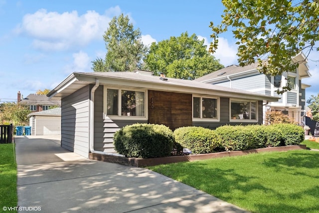 tri-level home featuring a garage, a front yard, and an outdoor structure