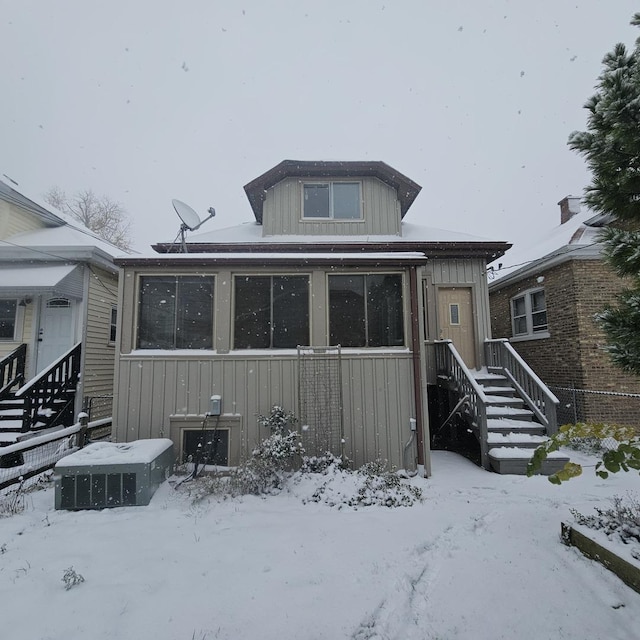 snow covered rear of property with board and batten siding