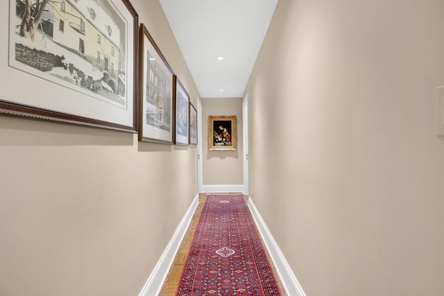 hall featuring recessed lighting and baseboards