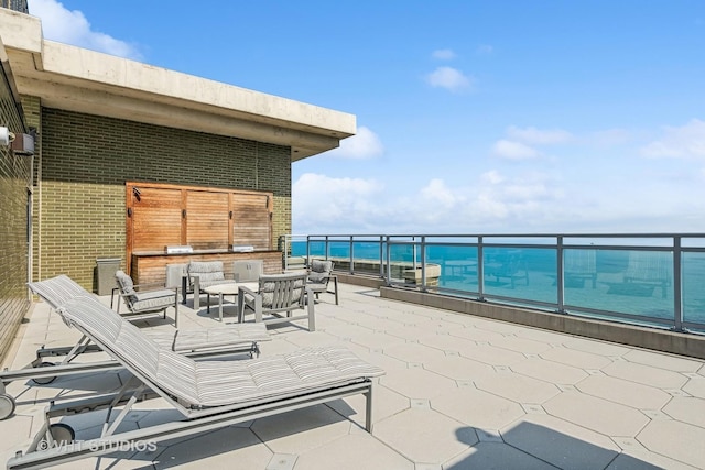 view of patio with a water view, a balcony, and outdoor lounge area