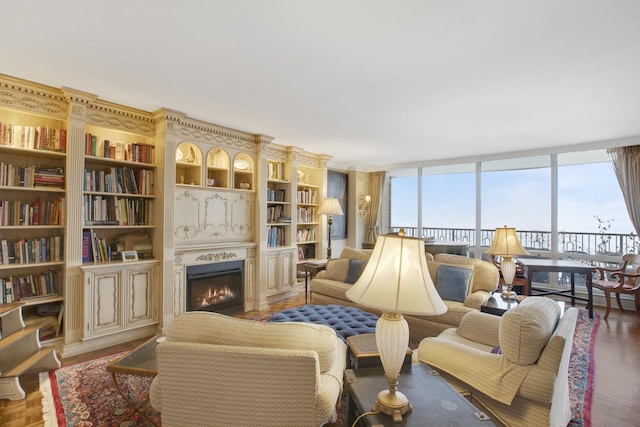 sitting room featuring a warm lit fireplace and a wall of windows