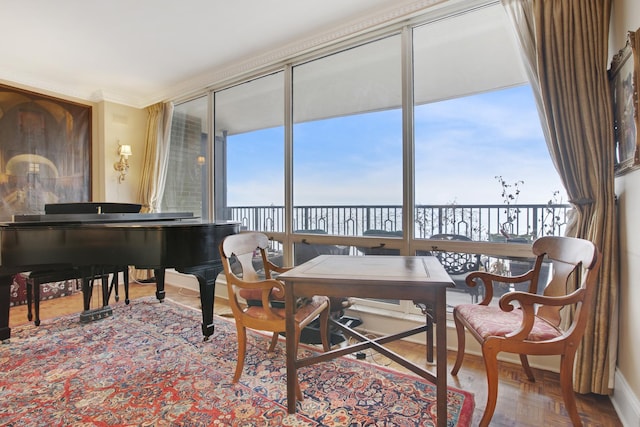 sitting room featuring a water view and crown molding