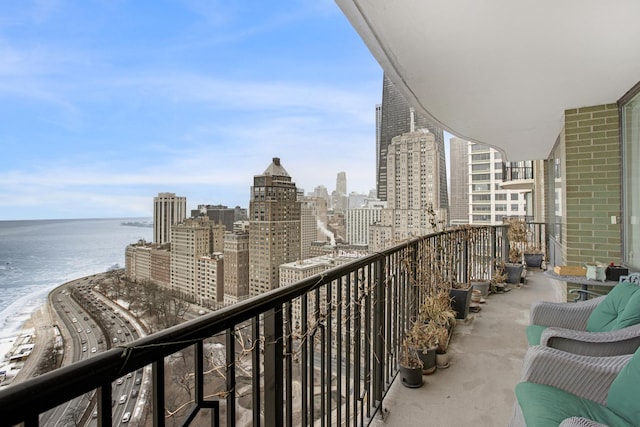 balcony with a view of the beach, a water view, and a city view