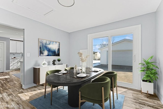 dining room featuring light wood-type flooring and baseboards