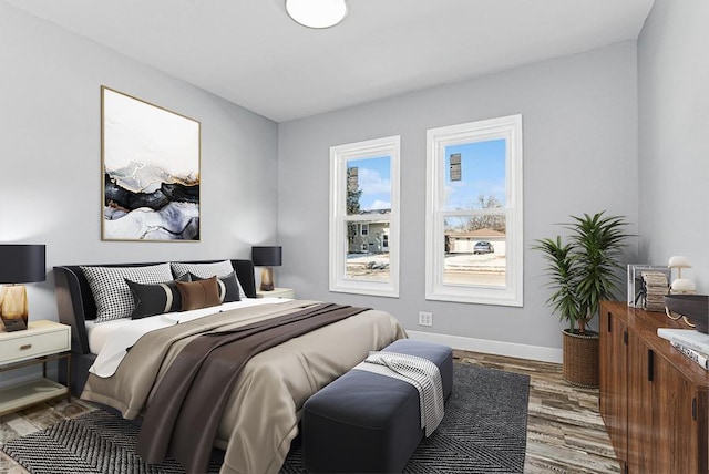 bedroom with wood finished floors and baseboards