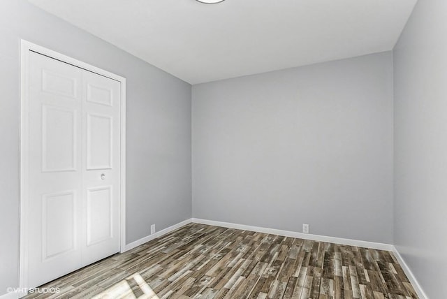 unfurnished bedroom featuring wood finished floors and baseboards