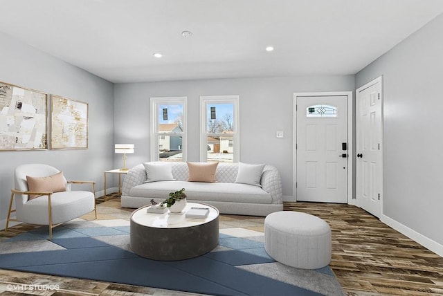 living area with baseboards, wood finished floors, and recessed lighting