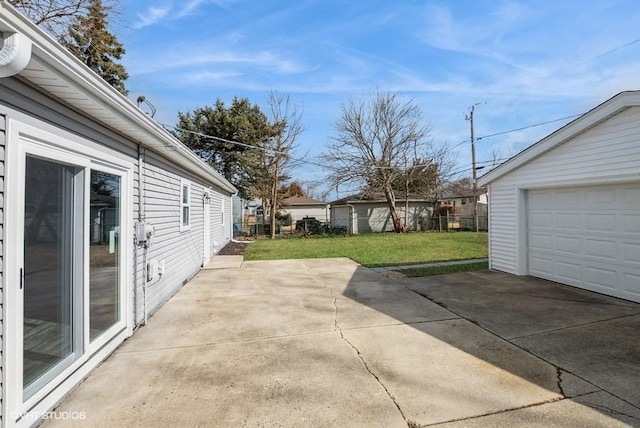 view of patio / terrace with a garage, concrete driveway, and fence