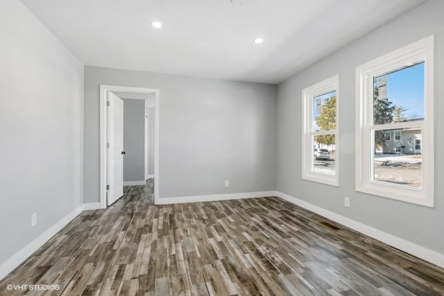 unfurnished room featuring baseboards, wood finished floors, and recessed lighting