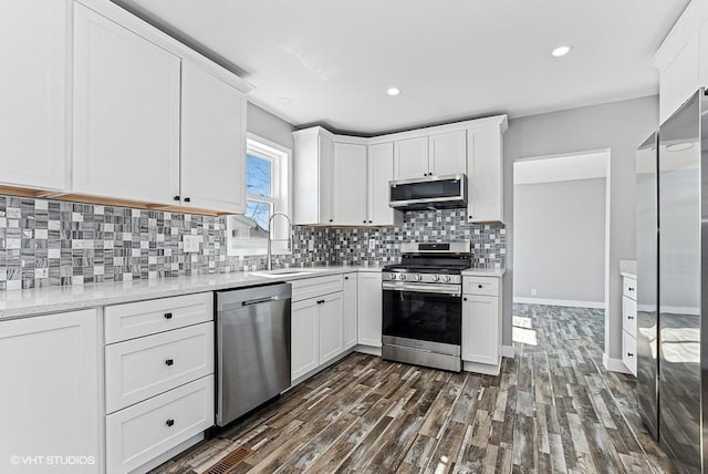 kitchen with stainless steel appliances, light countertops, a sink, and white cabinetry