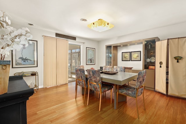 dining area featuring light wood-style floors and visible vents