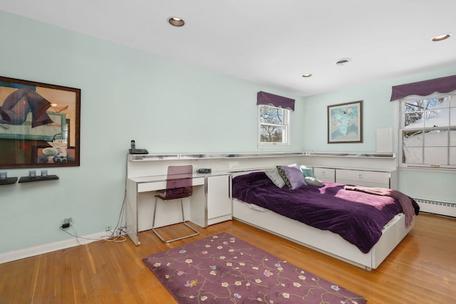 bedroom featuring light wood finished floors, a baseboard radiator, visible vents, and recessed lighting