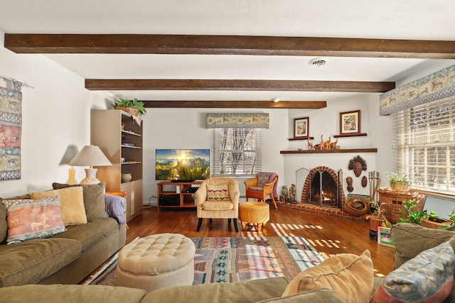 living area with plenty of natural light, wood finished floors, visible vents, and a brick fireplace