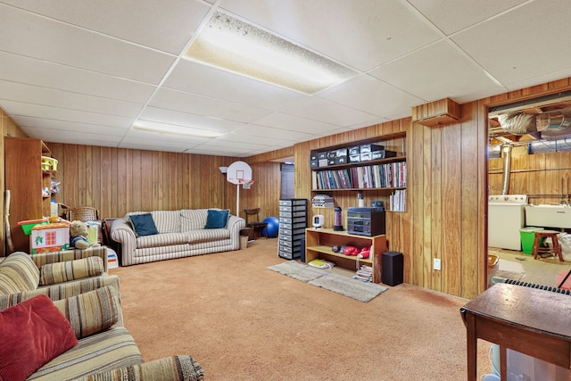 living area featuring washer / dryer, wooden walls, and carpet flooring