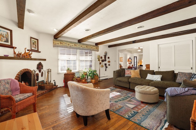 living room with a baseboard radiator, wood-type flooring, a fireplace, and beam ceiling