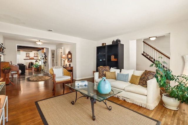 living area with baseboards, visible vents, stairway, wood finished floors, and a fireplace