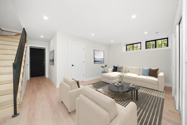 living area featuring light wood-style floors, recessed lighting, and stairs