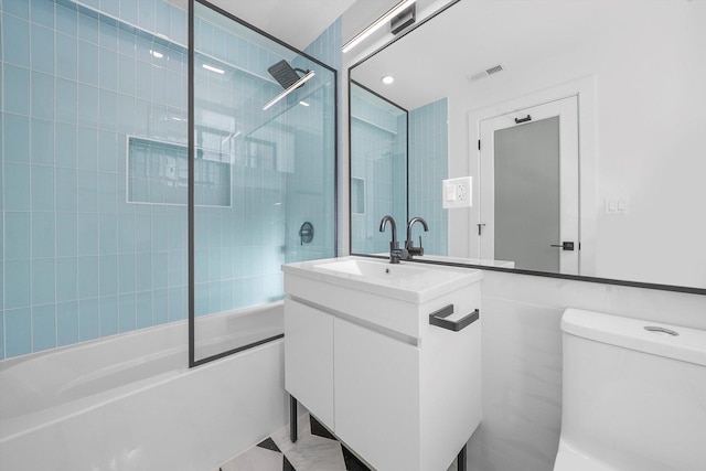 full bathroom featuring toilet, enclosed tub / shower combo, visible vents, and vanity