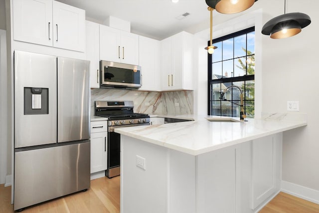 kitchen with stainless steel appliances, a sink, and white cabinets