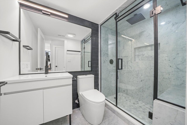 bathroom featuring toilet, a marble finish shower, tile walls, and vanity