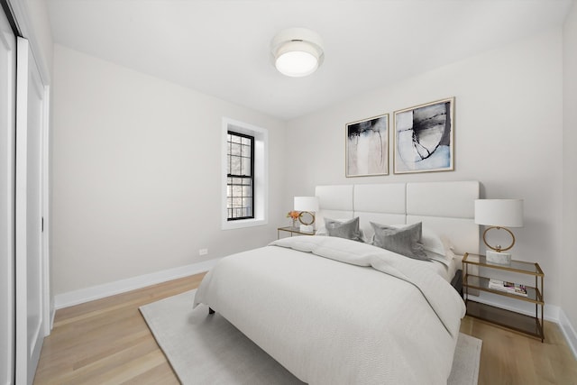 bedroom featuring light wood-style floors and baseboards