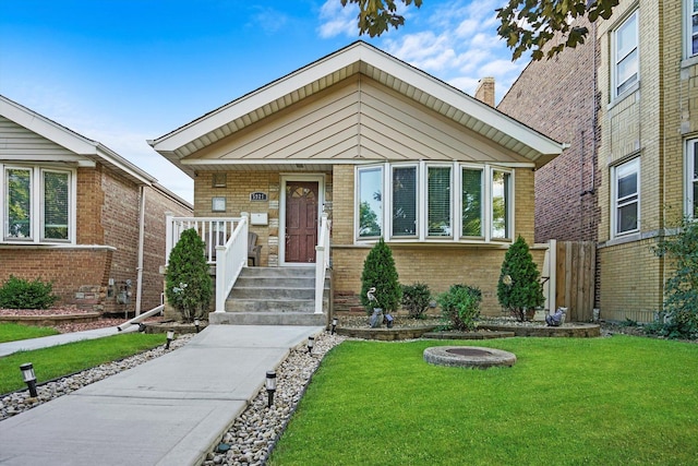 view of front of property featuring a front yard and brick siding