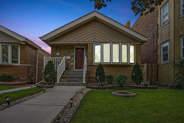 view of front of property featuring a yard and brick siding