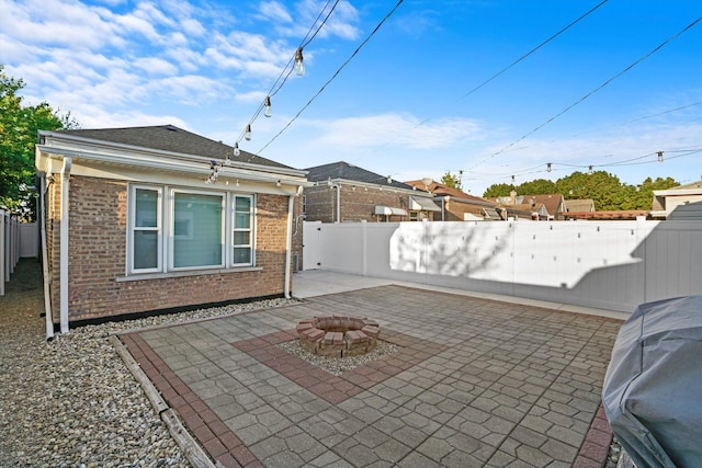 view of patio featuring an outdoor fire pit, a grill, and a fenced backyard