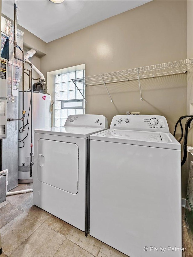 clothes washing area featuring washer and dryer, gas water heater, and laundry area